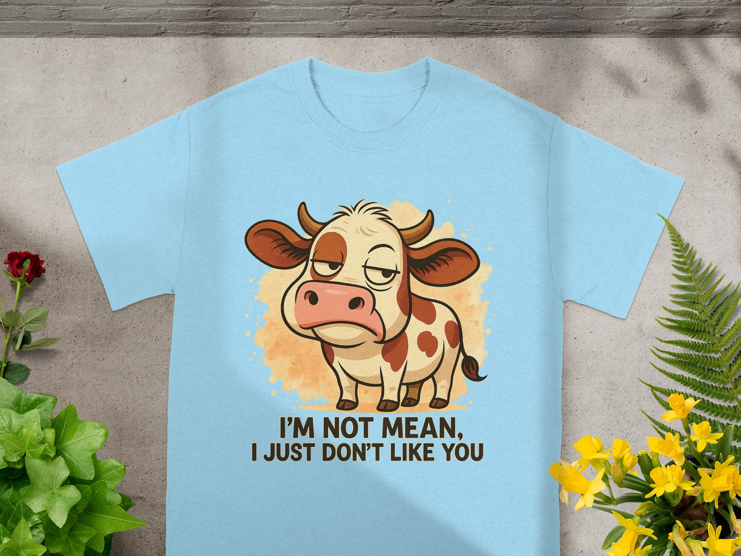 Light blue t-shirt with a grumpy cow illustration and text reading "I'm not mean, I just don't like you."