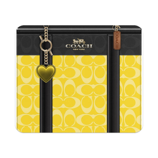 Coach New York yellow signature C pattern with gold heart charm and tag.