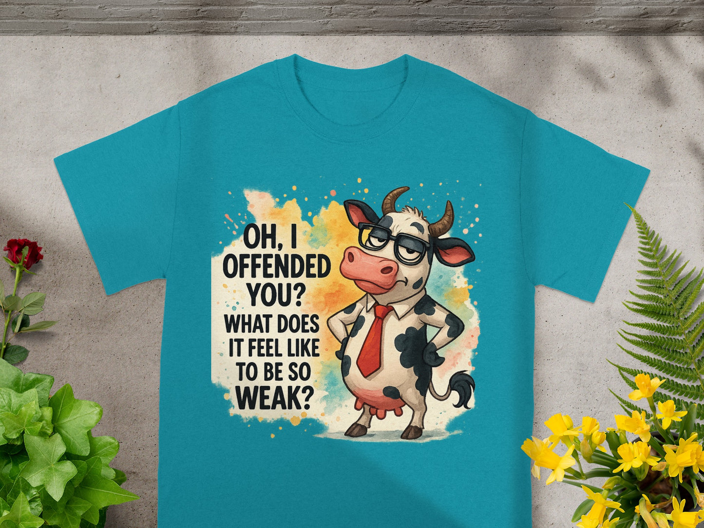 Teal t-shirt with cartoon cow asking "OH, I OFFENDED YOU? WHAT DOES IT FEEL LIKE TO BE SO WEAK?"