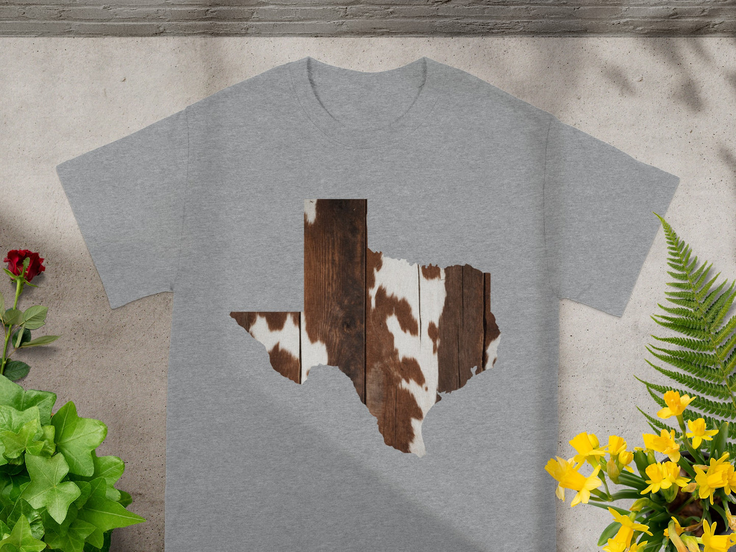 Grey t-shirt with a Texas shape graphic featuring wood grain and cowhide pattern.