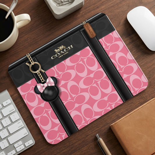 Coach accessory pouch with pink signature print and Minnie Mouse charm.