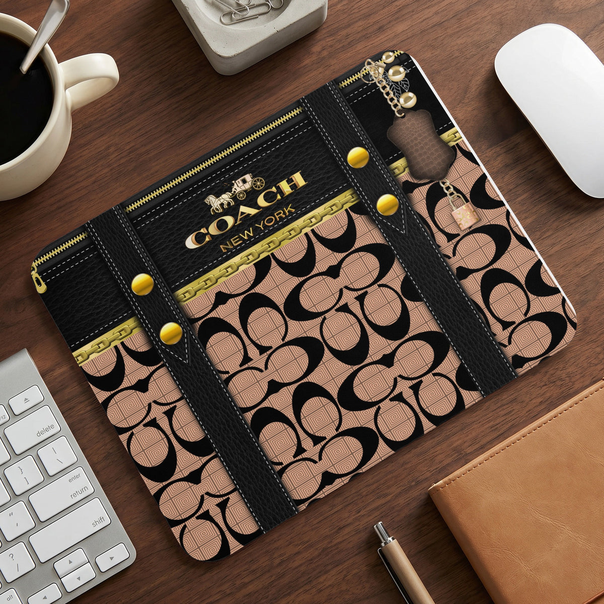 Coach New York pattern laptop sleeve with gold accents and attached lock.