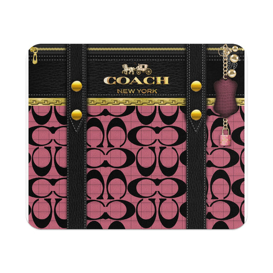 Coach pattern card holder with gold hardware and attached charms.