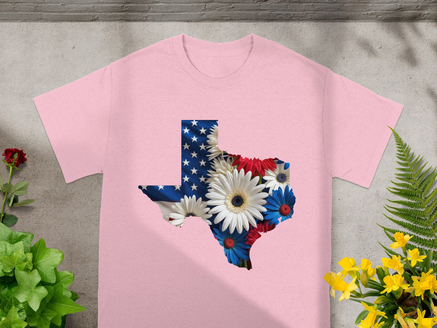 Pink t-shirt featuring Texas shape filled with American flag and flowers.